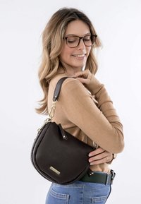 Zwarte leren schoudertas met een getextureerde afwerking, gebogen vorm en gouden hardware. Voorzien van een afneembare schouderband en ritssluitingen.