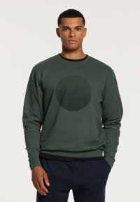 Groene sweatshirt van gestructureerde stof, met een cirkelvormig golvend patroon op de voorkant. Ronde halslijn en ribgebreide manchetten.