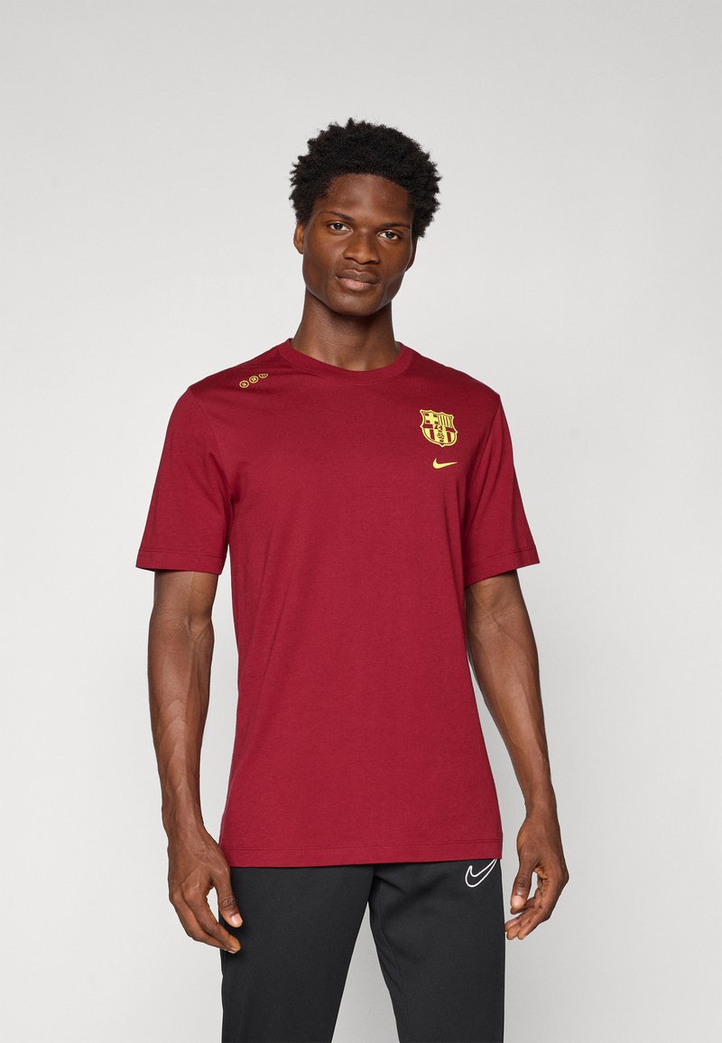 Bordo Nike t-särk lühikeste varrukatega, millel on rinnal kollane Barcelona logo ja kolm dekoratiivset nööpide õlal.