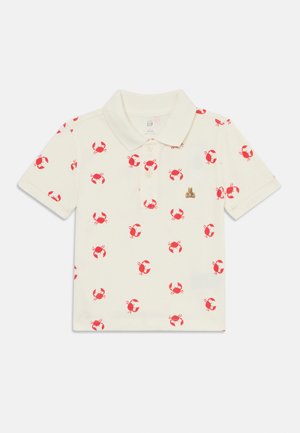 Polo en coton crème présentant un motif de crabe rouge répété. Comprend un col et une patte de boutonnage à trois boutons ; petit logo d'ours sur la poitrine.