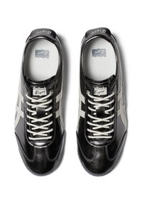 Sneaker in pelle nera con accenti bianchi, punta rotonda e design con lacci. Presenta una soletta texturizzata e una linguetta con logo.