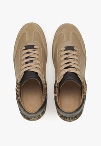 Tan leren sneakers met suède accenten, zwarte hak en details in luipaardprint. Heeft een ronde neus en platte veters. Voering zichtbaar aan de binnenkant.