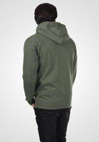 Olive green hoodie with a drawstring hood, long sleeves, and a relaxed fit. Material appears soft with a heathered texture. Back view.
