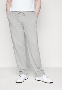 Grå sweatpants i mjukt material, med elastisk midja och dragsko, sidfickor och en liten blå Nike-logotyp.
