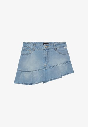 Minigonna asimmetrica in denim azzurro chiaro con tasche frontali, passanti per cintura, chiusura con bottoni e logo del marchio discreto sull'area della tasca destra.