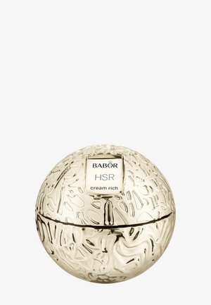 Guldfärgad sfärisk krämbehållare med strukturerade ytmönster. Etiketten visar "BABOR HSR cream rich" i en vit rektangel.