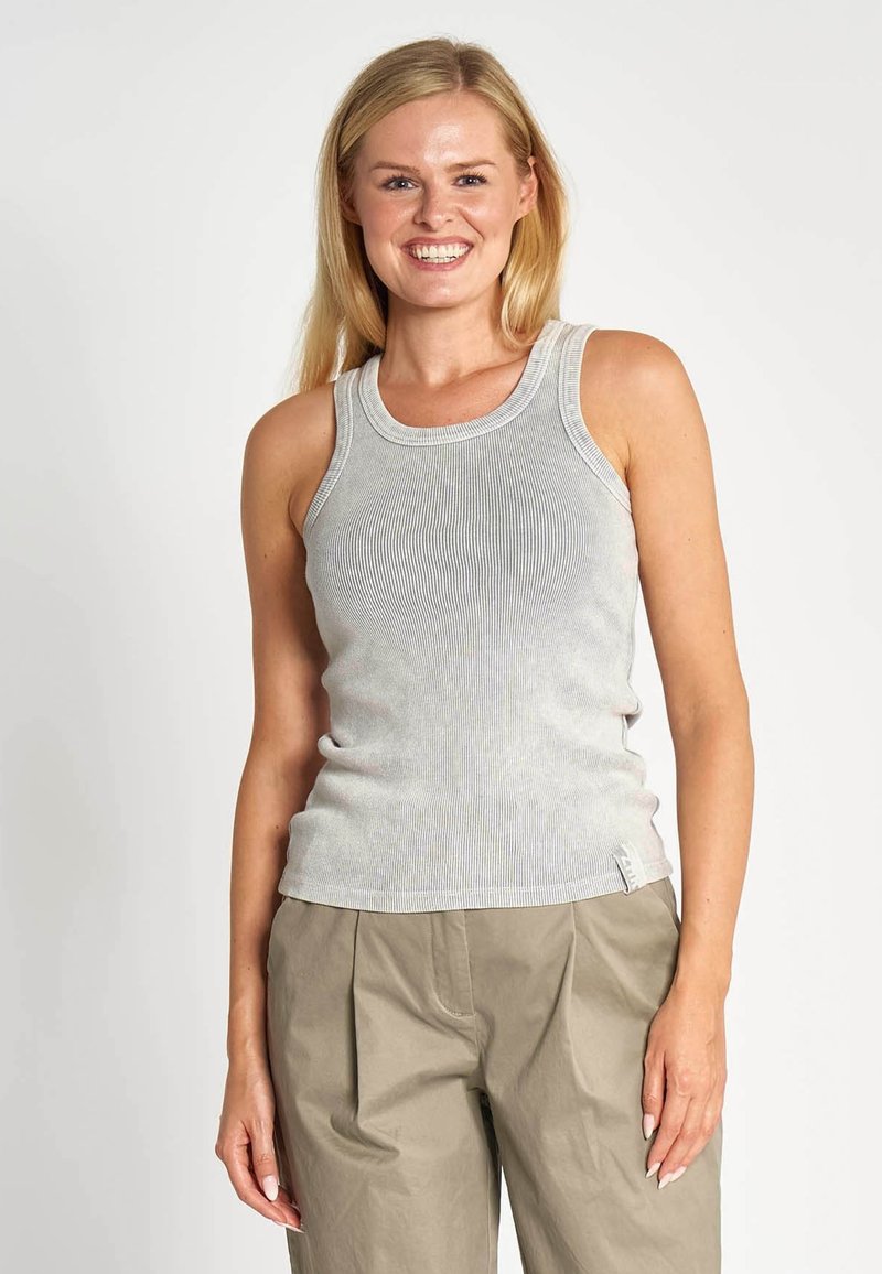 Hellgraues geripptes Tanktop aus Baumwolle mit rundem Ausschnitt und figurbetontem Schnitt. Kombiniert mit locker sitzenden Khakihosen.