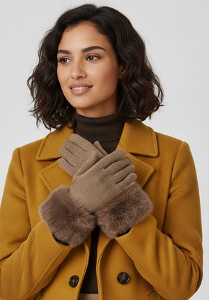 Brown knit gloves with soft fur cuffs, worn by a person in a yellow coat. Gloves are layered and form-fitting, with ribbed detailing.