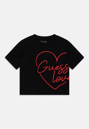 T-shirt noir court avec un contour de cœur néon rouge et les mots "Guess love" sur le devant, manches courtes, col rond.