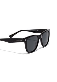 Ochelari de soare rectangulări negri cu lentile închise la culoare și marca "Hawkers" pe braț, pe un fundal alb.