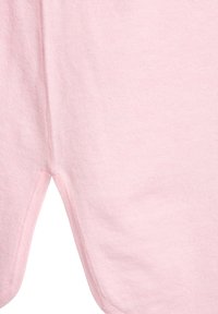 Svetloružová bavlnená tkanina s hladkým povrchom, vybavená zaobleným lemom a bočnými rozparkami pre väčšiu pohyblivosť, zdôrazňujúca pohodlie a ležérny dizajn.