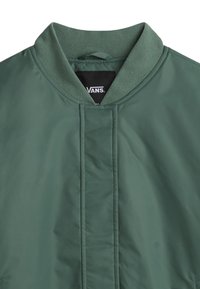 Groene, lichte bomberjack met een geribde kraag en nette stiksels. Merkkenning zichtbaar aan de binnenkant van de kraag. Soepele, matte textuur.