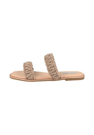 Sandale plate beige avec deux larges brides tressées sur le pied et une semelle lisse, marquée Steve Madden sur la semelle intérieure.