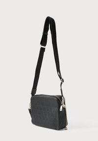 Μαύρο ορθογώνιο τσαντάκι ώμου με υφή σε σχήμα διαμαντιού, ασημένια μεταλλικά στοιχεία και ρυθμιζόμενο ιμάντα με λεπτομέρειες λογότυπου.