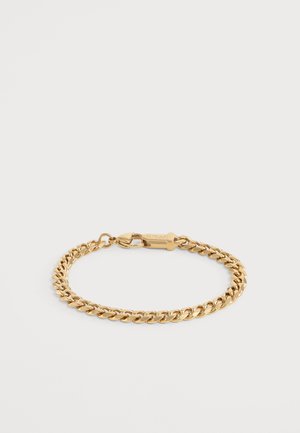 Bracelet chaîne couleur or avec maillons entrelacés et fermoir mousqueton sur un fond clair uni.