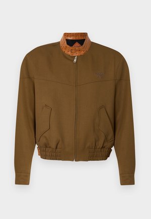 Chaqueta marrón con cremallera, cintura elástica, bolsillos delanteros inclinados y cuello con patrón en marrón claro contrastante, mostrada extendida.