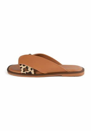 Svetlosmeđi kožni natikač s preklopljenim trakama i leopard printom kao akcentom. Ravni đon s teksturiranim gripom. Suvremeni dizajn prikladan za ležernu nošnju.