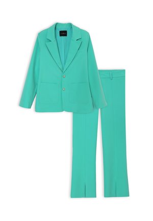 Completo turchese con giacca a risvolto, due tasche frontali e pantaloni slim-fit coordinati con spacchi alla caviglia.