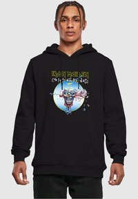 Black hoodie featuring a graphic of a zombie head, with "Iron Maiden" and "Can I Play with Madness" text in bright yellow and blue accents.