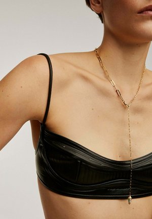 Bralette negro texturizado con tirantes finos, combinado con un collar largo de cadena dorada que presenta un acento decorativo.