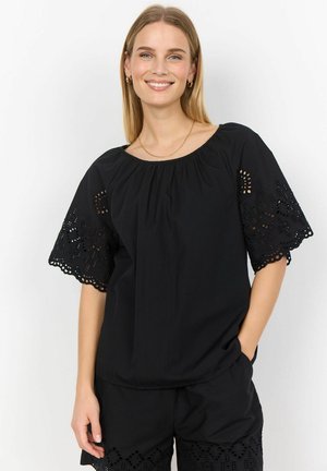 Black cotton blouse with a wide neckline and intricate cut-out lace detail on the short sleeves. Paired with black shorts featuring similar accents.