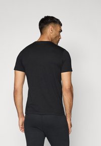 Zwarte t-shirt met korte mouwen, ronde hals, aansluitend ontwerp, gemaakt van zachte katoen, gladde textuur, minimale stikseldetails aan de randen.