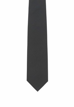 Narrow black tie featuring a textured fabric with small white polka dots. Ends in a pointed tip, offering a formal appearance.