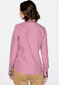 Punavalkoruudullinen pitkähihaisen kauluspaita, jossa on napilliset kalvosimet ja muotoiltu takakappale. Puuvillakangas, jossa on sileä pinta.