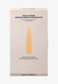 Multivitaminserum paket, mjuk beige låda med framträdande svart text. Innehåller sju ampuller, visade med en orange konturdesign.
