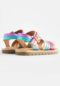 Multikleurige sandalen met metallic paarse, teal, roze en gouden banden met een gesp, en een gestructureerde bruine zool.
