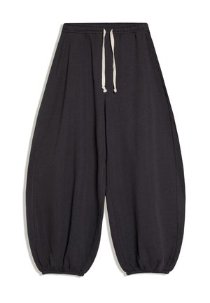 Schwarze weite Hose mit elastischem Bund, weißem Kordelzug und gesmokten elastischen Bündchen an den Knöcheln.