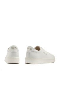 Białe skórzane sneakersy z wytłoczonym logo "RKO", teksturowanym wykończeniem, zaokrąglonym noskiem i płaską gumową podeszwą. Minimalistyczny design z zapięciem na sznurówki.
