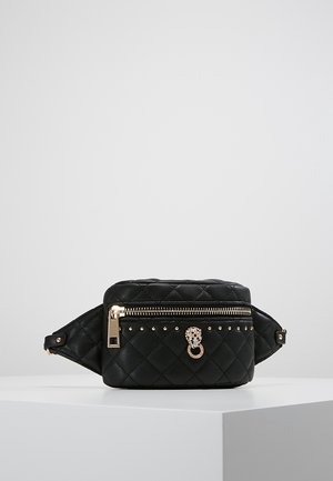 Czarna pikowana skórzana nerka z złotym zamkiem błyskawicznym, złotymi ćwiekami i ozdobnym pierścieniem w kształcie głowy lwa z biżuterią na przedniej kieszeni.