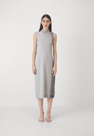 Sleeveless gray dress with a high neckline, featuring a gradient shimmer effect, knee-length cut, and solid hem. Worn with silver strappy sandals.