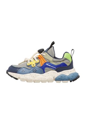 Sneaker multicolore con suola spessa maculata, pannelli blu e verdi, lacci elastici bianchi e dettaglio arancione sul lato.