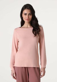Maglia a manica lunga in morbido tessuto rosa pallido con scollo a barca e design semplice. Presenta polsini a costine e una vestibilità rilassata. Abbinata a pantaloni coordinati.