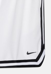 T-shirt de sport blanc avec des accents noirs, en tissu texturé et un petit logo noir de Nike près de l'ourlet. Rayures horizontales en bas.