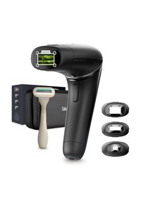 Black electric device with a rounded head, displaying green lights. Includes a beige manual razor and three black attachments, in a box.