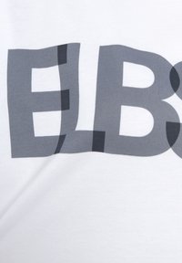 Weißes Baumwoll-T-Shirt mit großen grauen Buchstaben in unterschiedlichen Schriftarten und -stärken, das die Buchstaben "ELB" prominent zeigt.