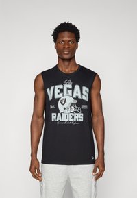 Čierne bezrukávové bavlnené tričko s grafikou "Las Vegas Raiders" a futbalovou prilbou v bielej a svetlomodrej farbe. Mäkka textúra.