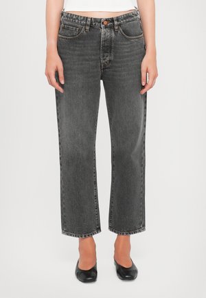 High-waisted, straight-leg jeans in faded black denim. Features five pockets and contrast stitching. Legs are slightly loose at the hem.