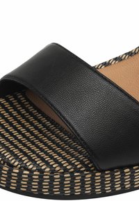Svart slide-sandal med en slät läderöverdel och en vävd, strukturerad sula. Sulan har ett randigt mönster i svart och beige.