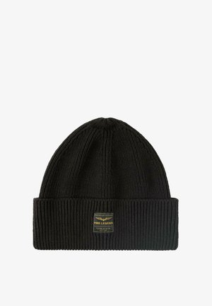 Zwarte gebreide beanie met een geribde textuur, voorzien van een omgeslagen rand en een rechthoekig etiket met gouden tekst aan één zijde.