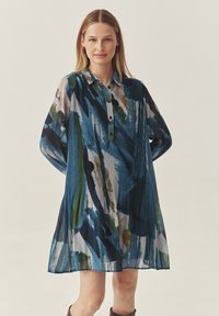 Bunt gemustertes Kleid mit Kragen, Knopfleiste und langen Ärmeln. Hergestellt aus leichtem Stoff, der blaue, grüne und weiße Pinselstriche zeigt.