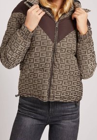 Padded Jacke in Braun und Khaki mit einem gemusterten Stoff, Reißverschluss und elastischen Bündchen. Verfügt über eine kontrastierende braune Seite an den Schultern.