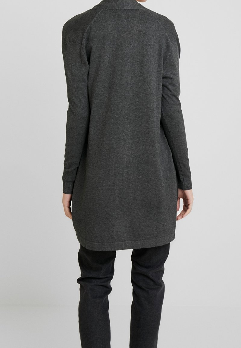 Langärmlige, dunkelgraue Strickjacke aus weichem Strickstoff, mit rundem Halsausschnitt und geradem Saum, getragen über schwarzen Hosen.