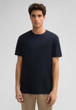 T-shirt à manches courtes bleu marine fabriqué en tissu doux, doté d'un col rond classique et d'une coupe décontractée. Texture lisse, design simple.
