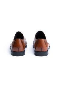 Braune Lederschuhe mit glatter Oberfläche, runder Zehenpartie, niedriger schwarzer Gummisohle und subtilen Nähten. Ansicht von hinten.