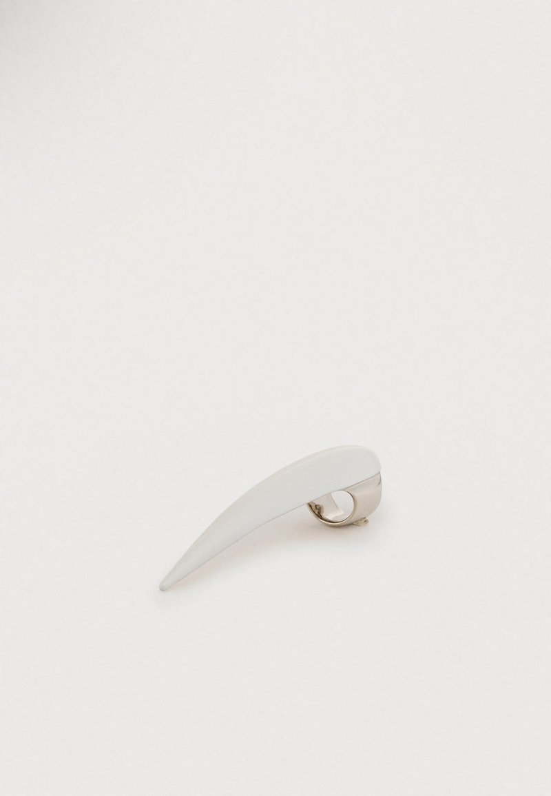 Λευκό κλιπ για τα μαλλιά με κομψό, επιμηκυμένο σχέδιο και λαμπερό ασημένιο κούμπωμα. Ομαλή υφή με ελαφριά καμπύλη, που αναδεικνύει το μινιμαλιστικό του στυλ.