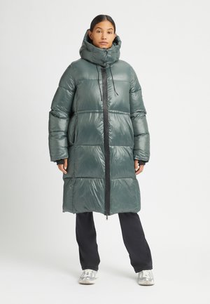 Gewatteerde lange jas in glanzend donkergroen met een hoge kraag, ritssluiting aan de voorkant en een oversized silhouet. Bevat elastische manchetten en zijzakken.